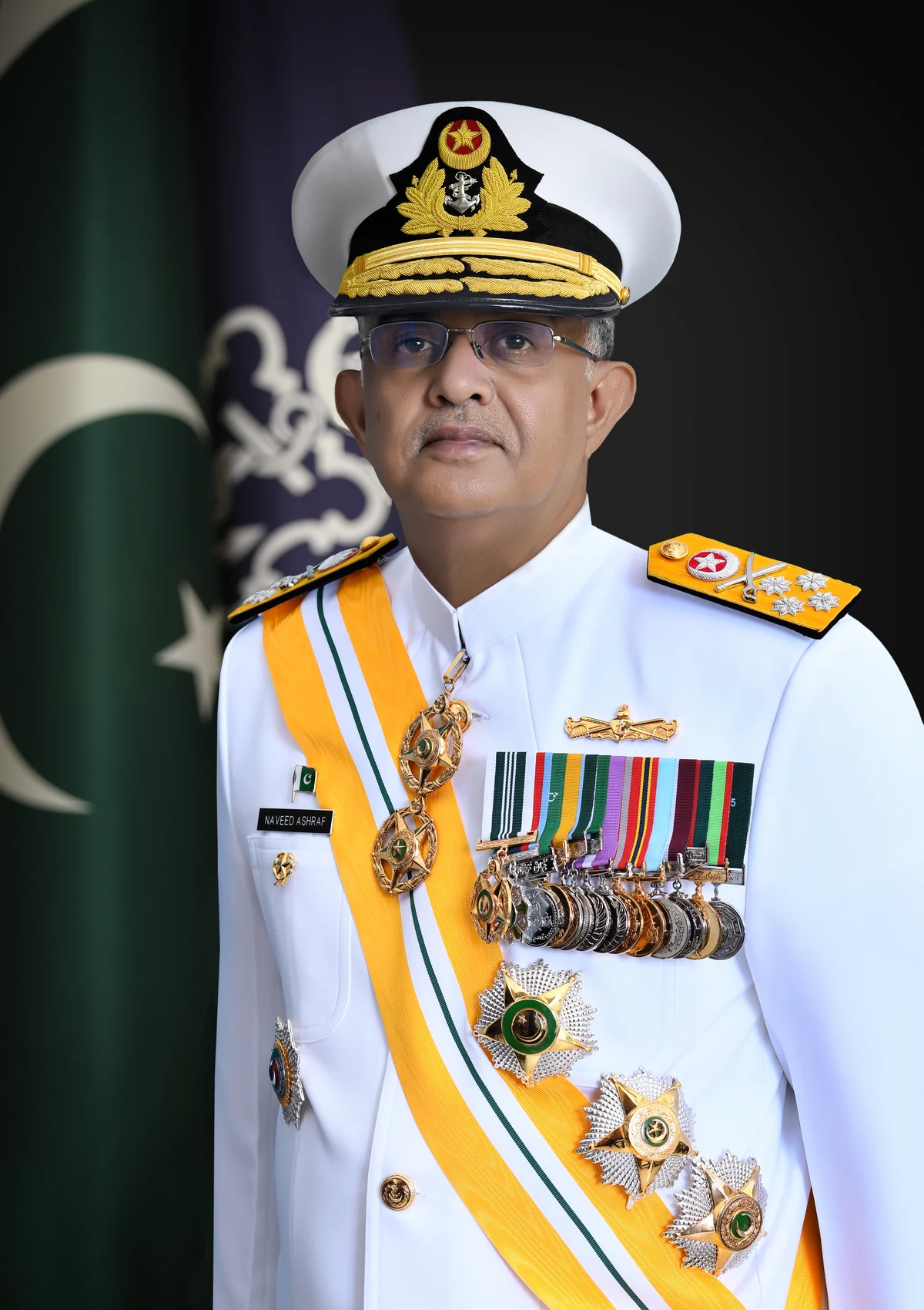 Admiral Naveed Ashraf in naval dress uniform, with the Pakistan flag behind him.