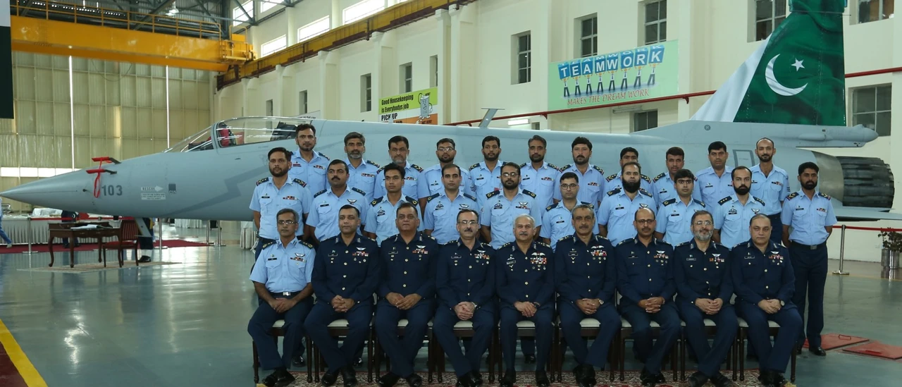 Personnel beside a JF-17 at Pakistan Aeronautical Complex’s overhaul facility.