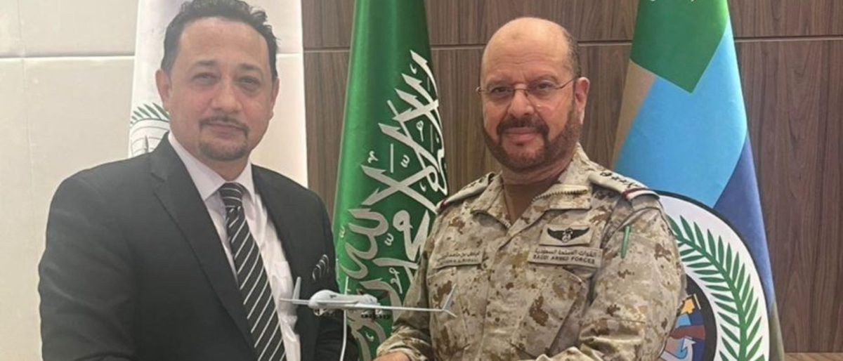 Photo of two officials exchanging a small model of a drone.