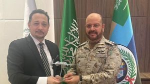 Photo of two officials exchanging a small model of a drone.