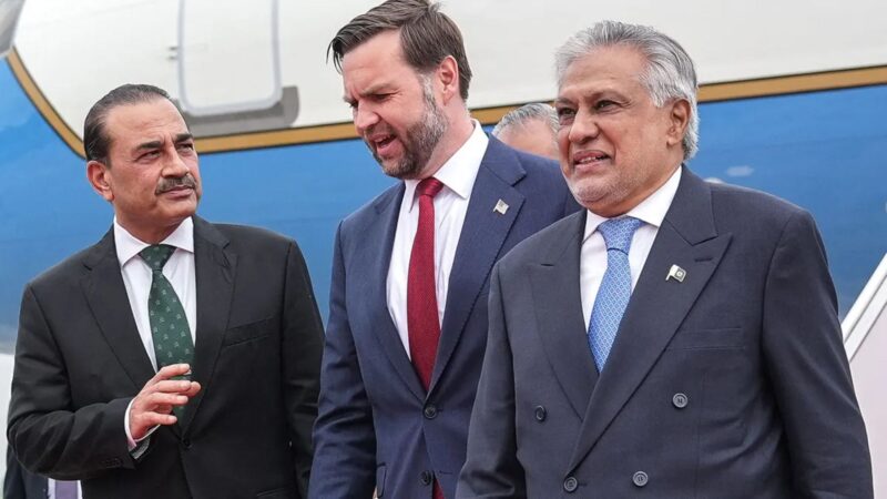 Three men in suits walking together on a tarmac, near a blue airplane in the background, appearing to greet each other at arrival.