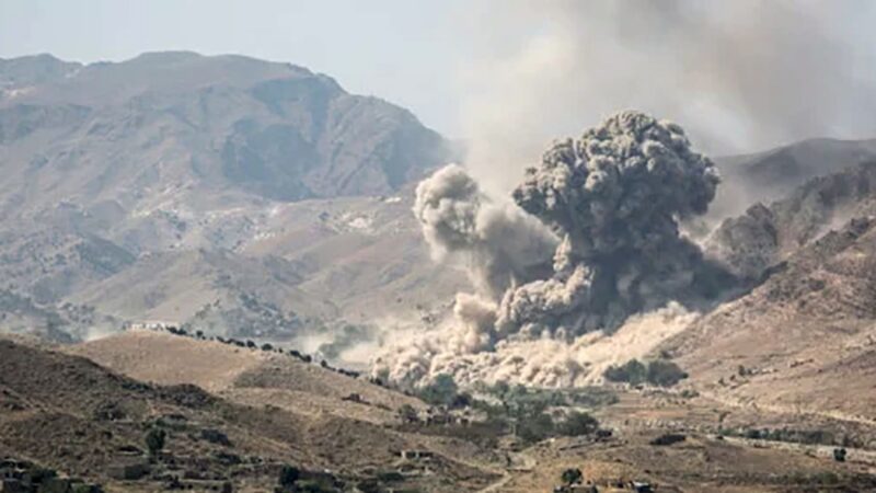 Volcanic eruption in a barren valley, with a large mushroom-shaped ash cloud rising from the crater.