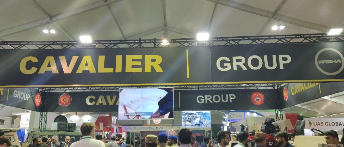 Large overhead sign reads 'CAVALIER GROUP' in yellow letters on a dark backdrop at an indoor exhibition, with a crowd of attendees below.