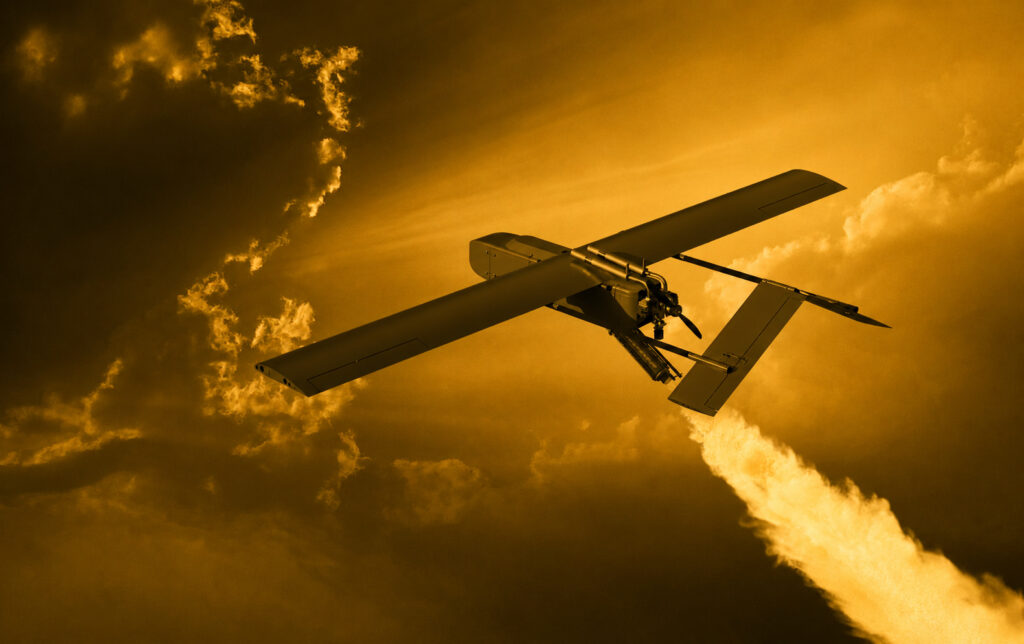 Unmanned aerial vehicle with long wings flying through a golden sunset sky.