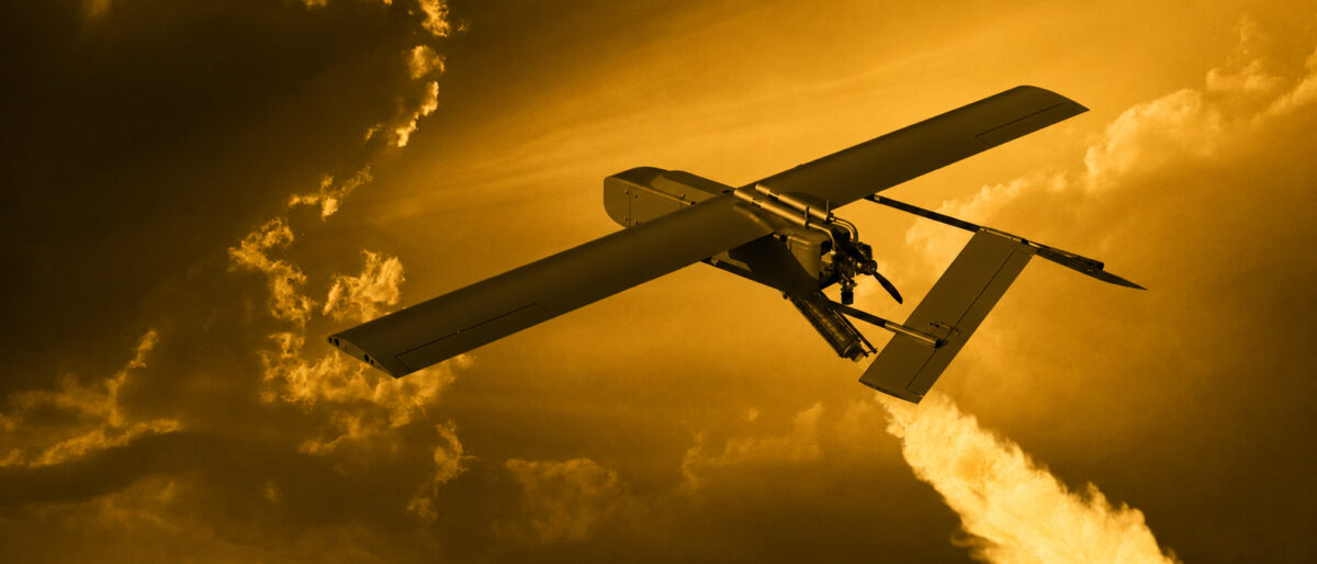 Unmanned aerial vehicle with long wings flying through a golden sunset sky.