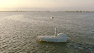 A Thunder Tiger SeaShark unmanned surface vessel underway at Dapeng Bay, Taiwan, with a second vessel in the background, during the Shield AI Hivemind autonomous teaming demonstration