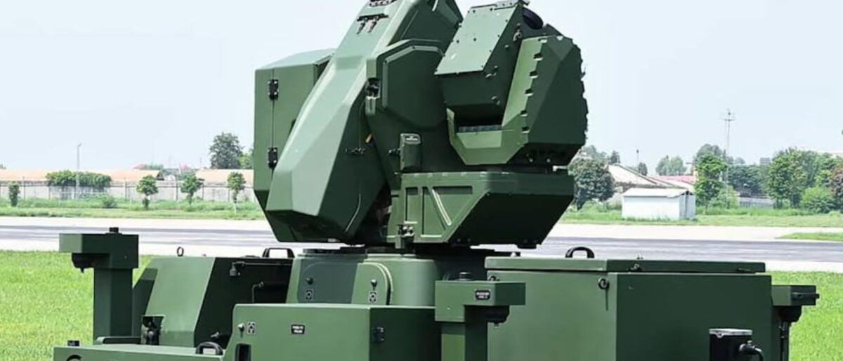 Green military mobile launcher with an elevated array mounted on a tracked chassis, outdoors on grass server side.