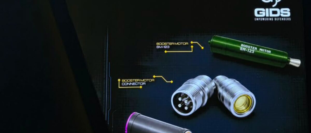 GIDS display with a green booster motor labeled BM-123 and metallic connectors on a dark technical background.