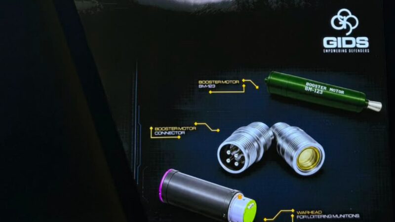 GIDS display with a green booster motor labeled BM-123 and metallic connectors on a dark technical background.