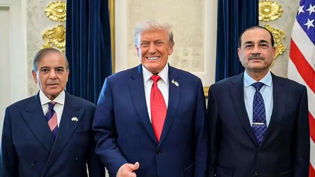 Three men in dark suits posing for a formal photo in a room with blue curtains and a visible U.S. flag, smiling at the camera.