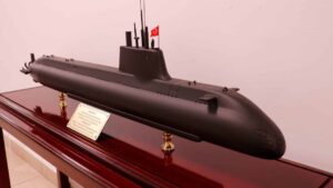 Scale model submarine with a Turkish flag on top, mounted on a polished wooden display stand with a plaque.
