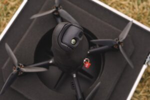 Origin Robotics BLAZE interceptor drone in its transport case, showing the electro-optical and infrared sensor turret