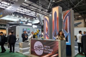 Ukraine's national pavilion at Eurosatory 2026 with SpetsTechnoExport branding and Ukrainian UAVs suspended above the stand