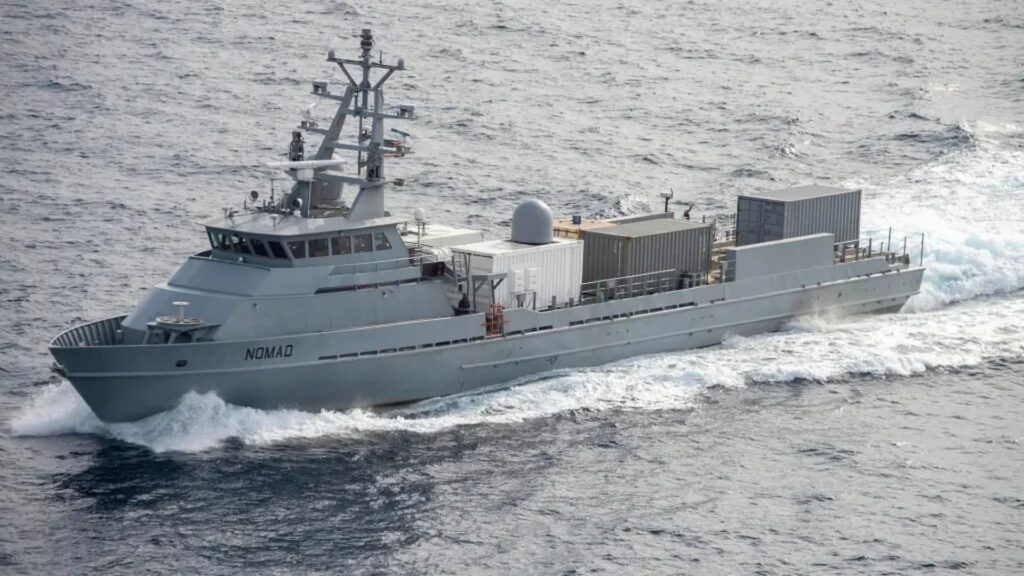Containerized Munitions - Quwa Gray research/support vessel named Nomad cuts through waves with stacked cargo containers on its deck.