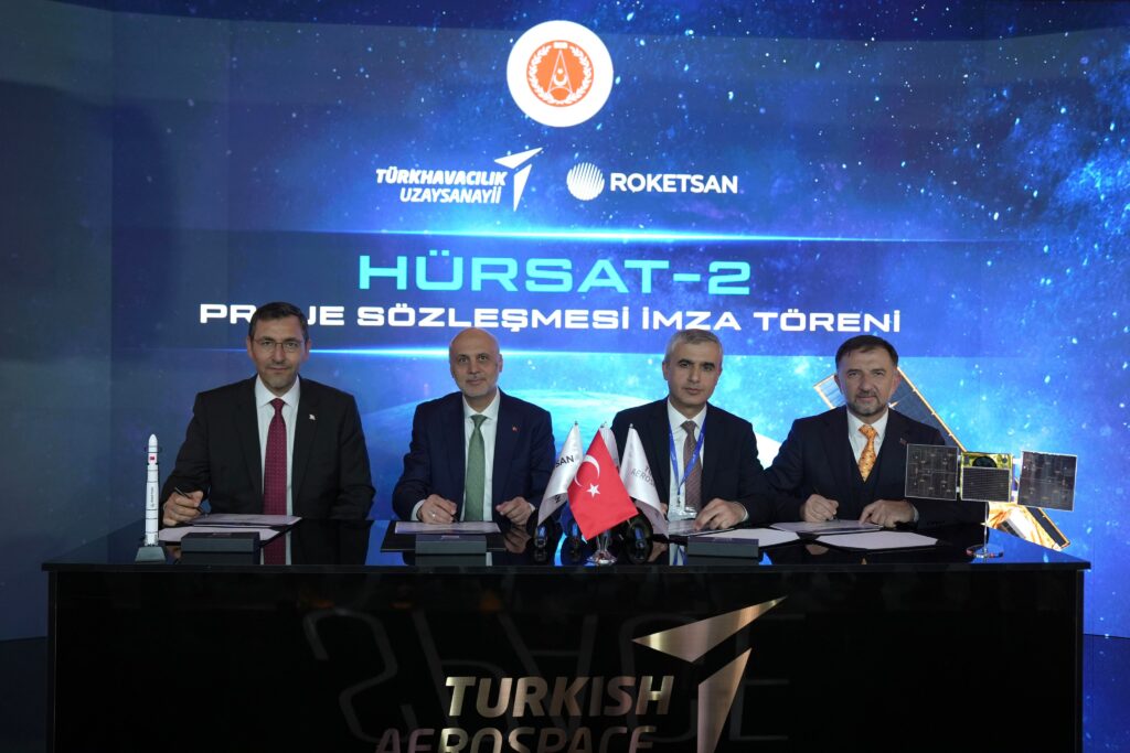 Officials at the HÜRSAT-2 agreement signing with TUSAŞ and ROKETSAN branding behind them